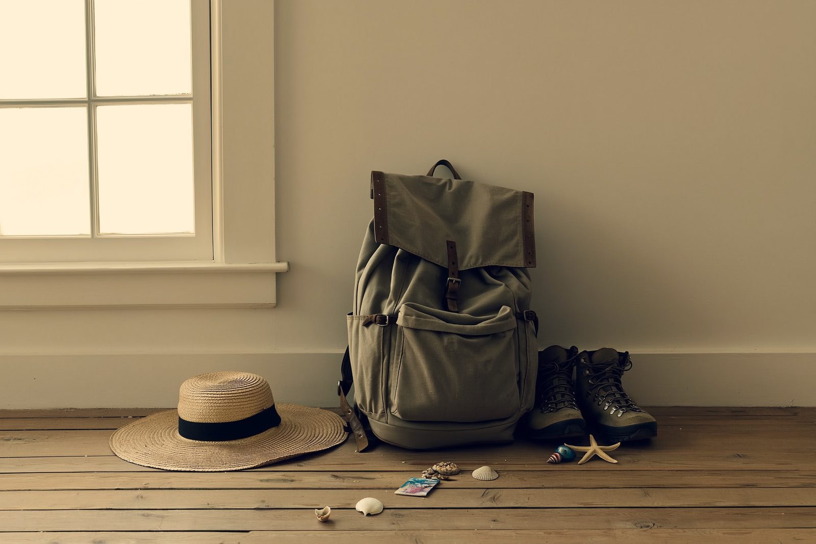 Abgewetzter Reiserucksack mit Wanderschuhen und Souvenirs auf Holzboden